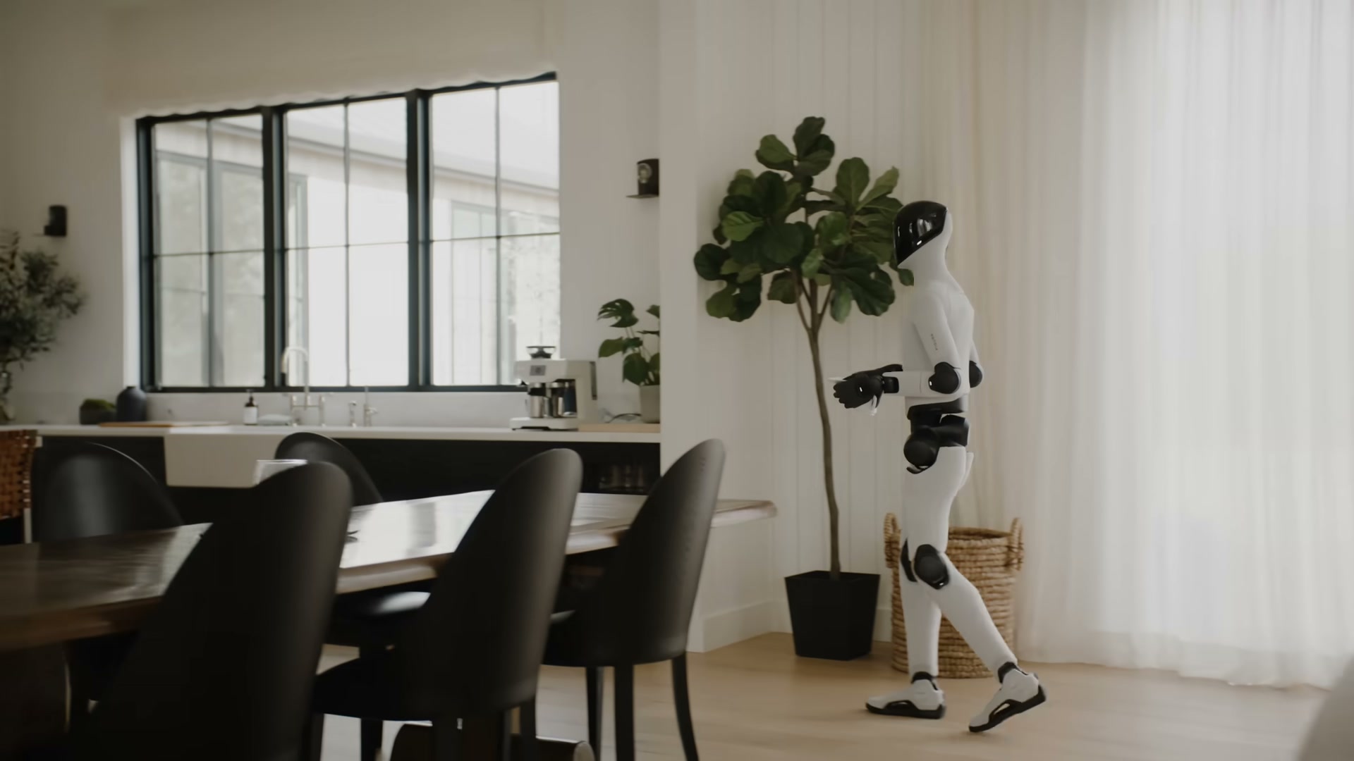 Figure 03 walking through a kitchen/dining area, frame from Figure's official Figure 03 reveal video (timestamp 180s).